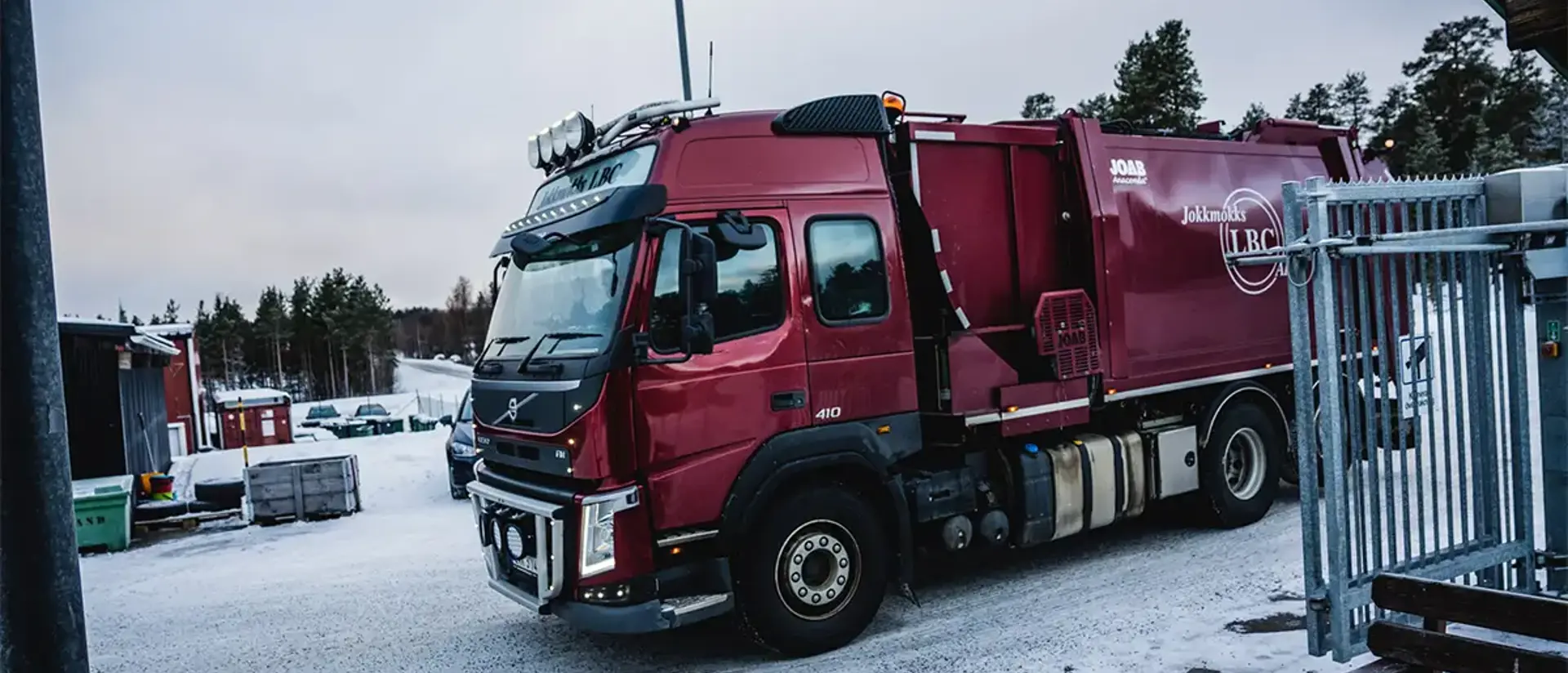 En vinröd sopbil kör in genom grinarna på Återvinningscentralen i Jokkmokk. Foto: CJ Utsi.